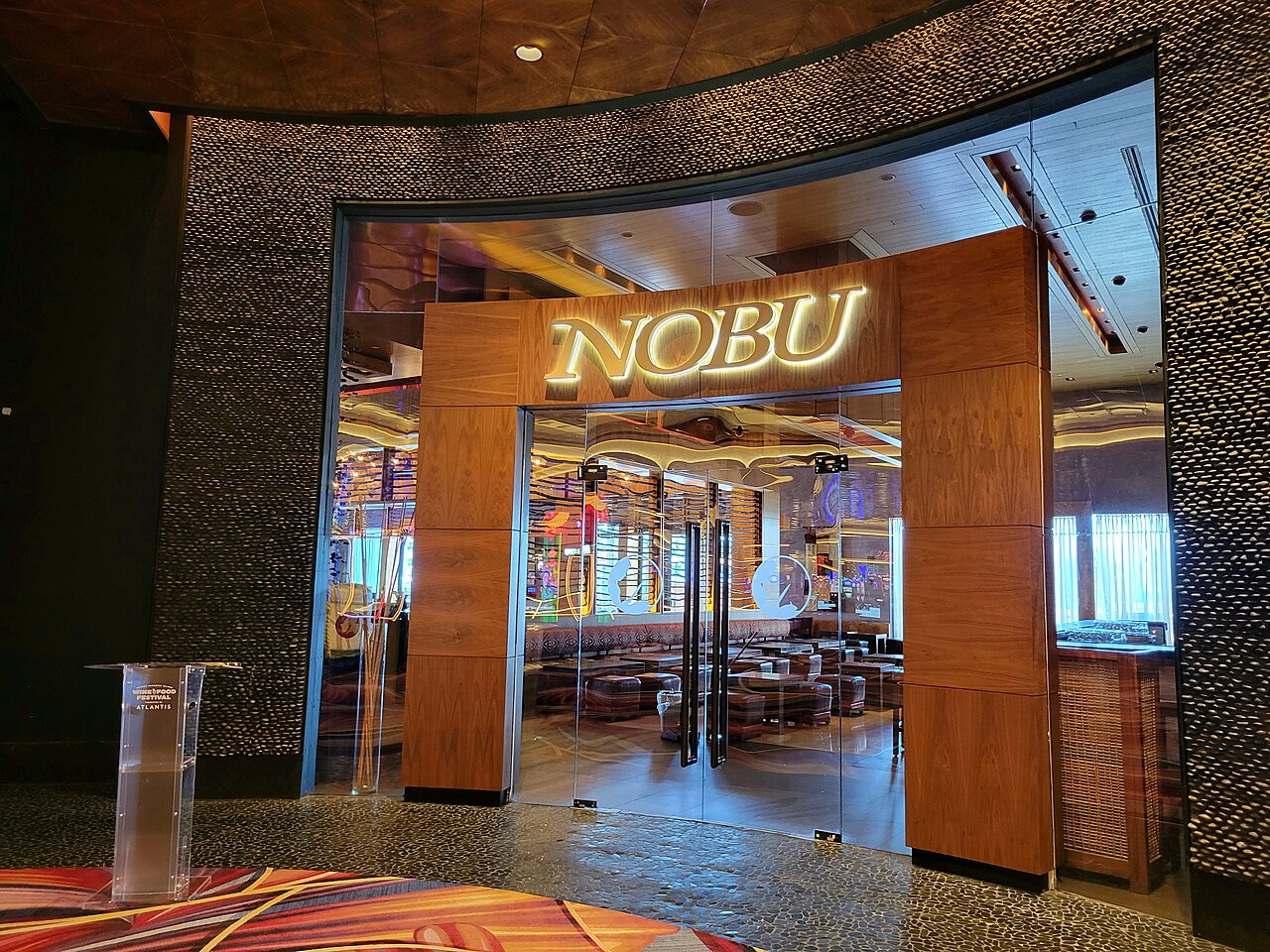 Luxurious Nobu restaurant interior at Atlantis Paradise Island, featuring elegant Japanese-inspired design with sleek wooden surfaces, contemporary dining spaces, and panoramic views of the Caribbean waters, showcasing a high-end culinary destination.