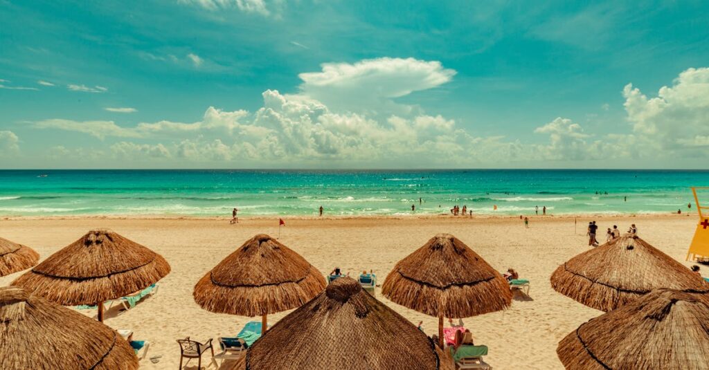 A vibrant beach scene in Cancun, Mexico with straw umbrellas and turquoise sea under a bright sky.