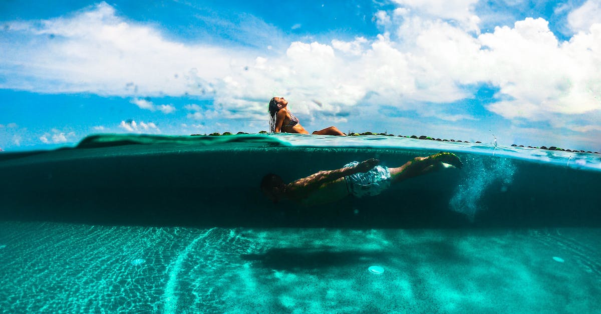 Vibrant shot of people enjoying a sunny day in a Cancun pool, merging above and underwater views.