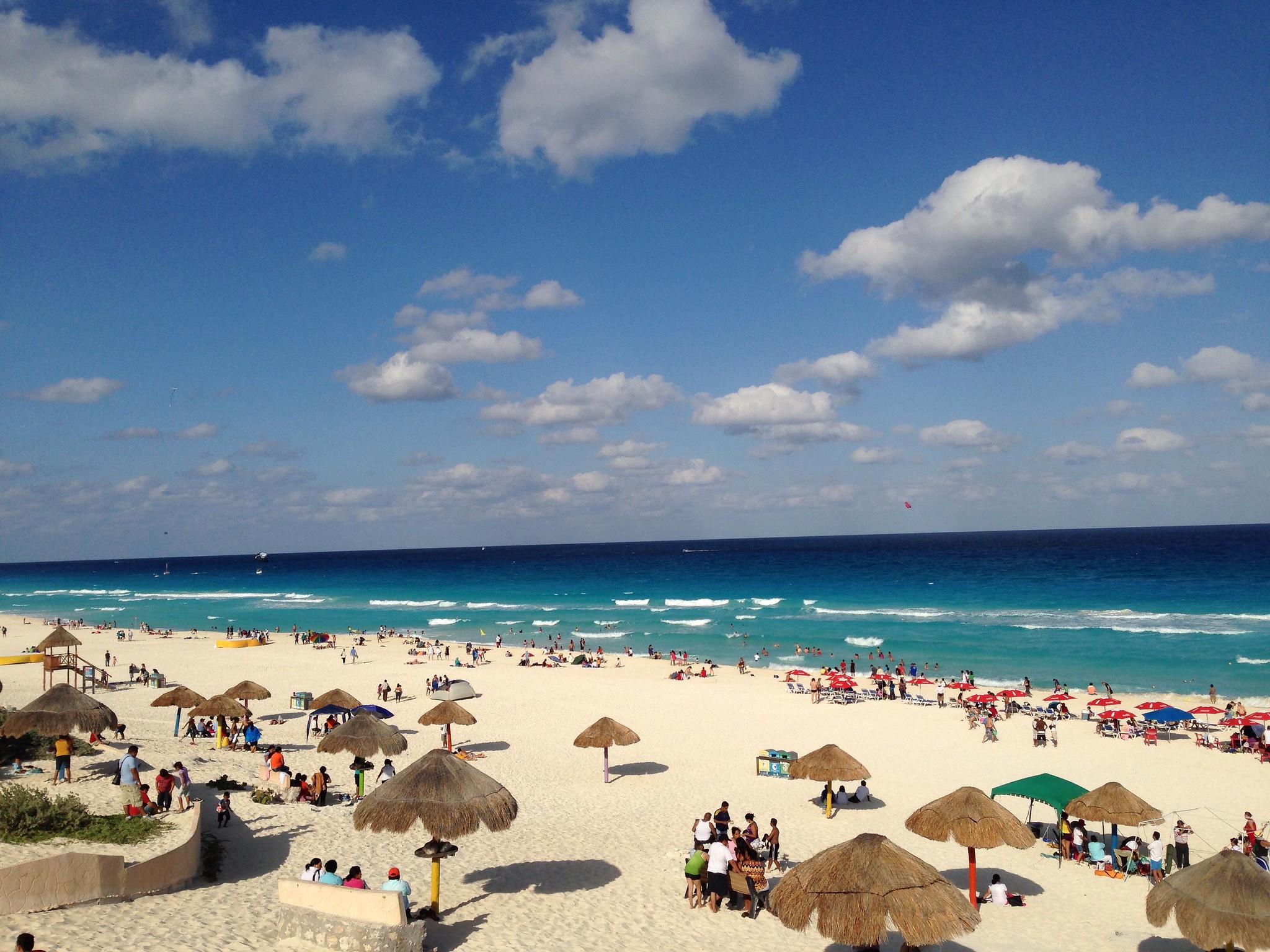 Turquoise waters and white sand of Playa Delfines, Cancun, with colorful 'Cancun' sign and pristine beach landscape.